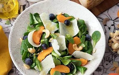 Insalatona con valeriana, albicocche, anacardi, mirtilli, menta e scaglie di Grana Padano