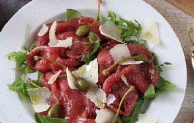 Carpaccio di manzo con capperi, rucola e scaglie di Grana Padano Riserva