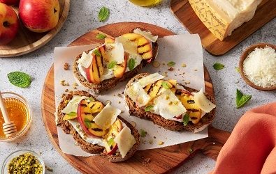 Crostini con crema di ricotta e Grana Padano, pesche grigliate, miele, menta e granella di pistacchi