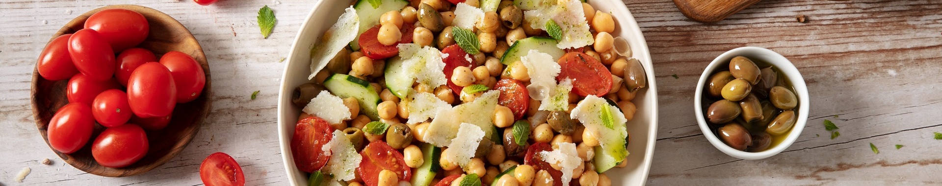 Insalata di ceci con pomodorini datterino confit, olio alla menta, cetrioli, olive taggiasche e scaglie di Grana Padano