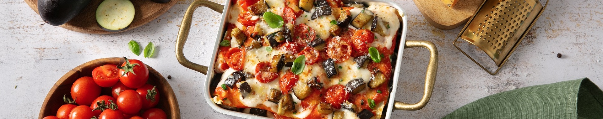 lasagne con pomodoro, melanzane fritte, pomodorini, basilico e besciamella al Grana Padano