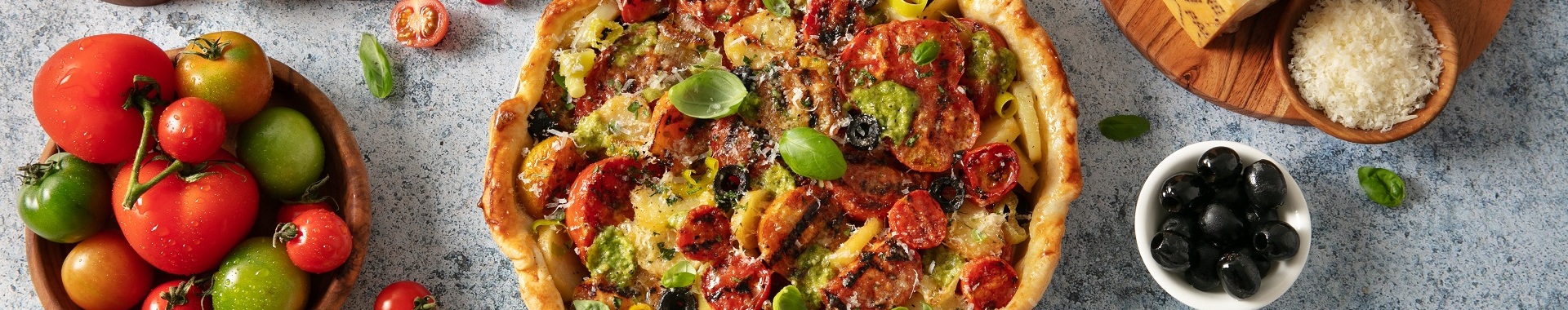 Torta salata con porri, patate, pomodori grigliati, pesto, olive e Grana Padano.