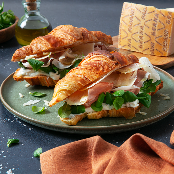 Tramezzini di pane integrale con cavolo viola marinato, crema al Grana Padano con erba cipollina, affettato di tacchino, insalata, cetriolini e scaglie di Grana Padano