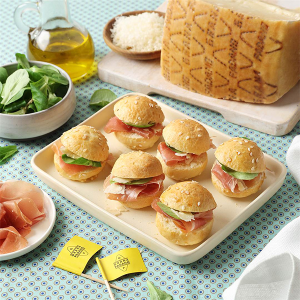 Tramezzini di pane integrale con cavolo viola marinato, crema al Grana Padano con erba cipollina, affettato di tacchino, insalata, cetriolini e scaglie di Grana Padano