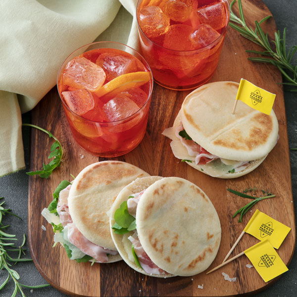 Tramezzini di pane integrale con cavolo viola marinato, crema al Grana Padano con erba cipollina, affettato di tacchino, insalata, cetriolini e scaglie di Grana Padano