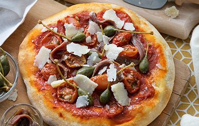Pizza con pomodorini, acciughe, capperi e Grana Padano DOP